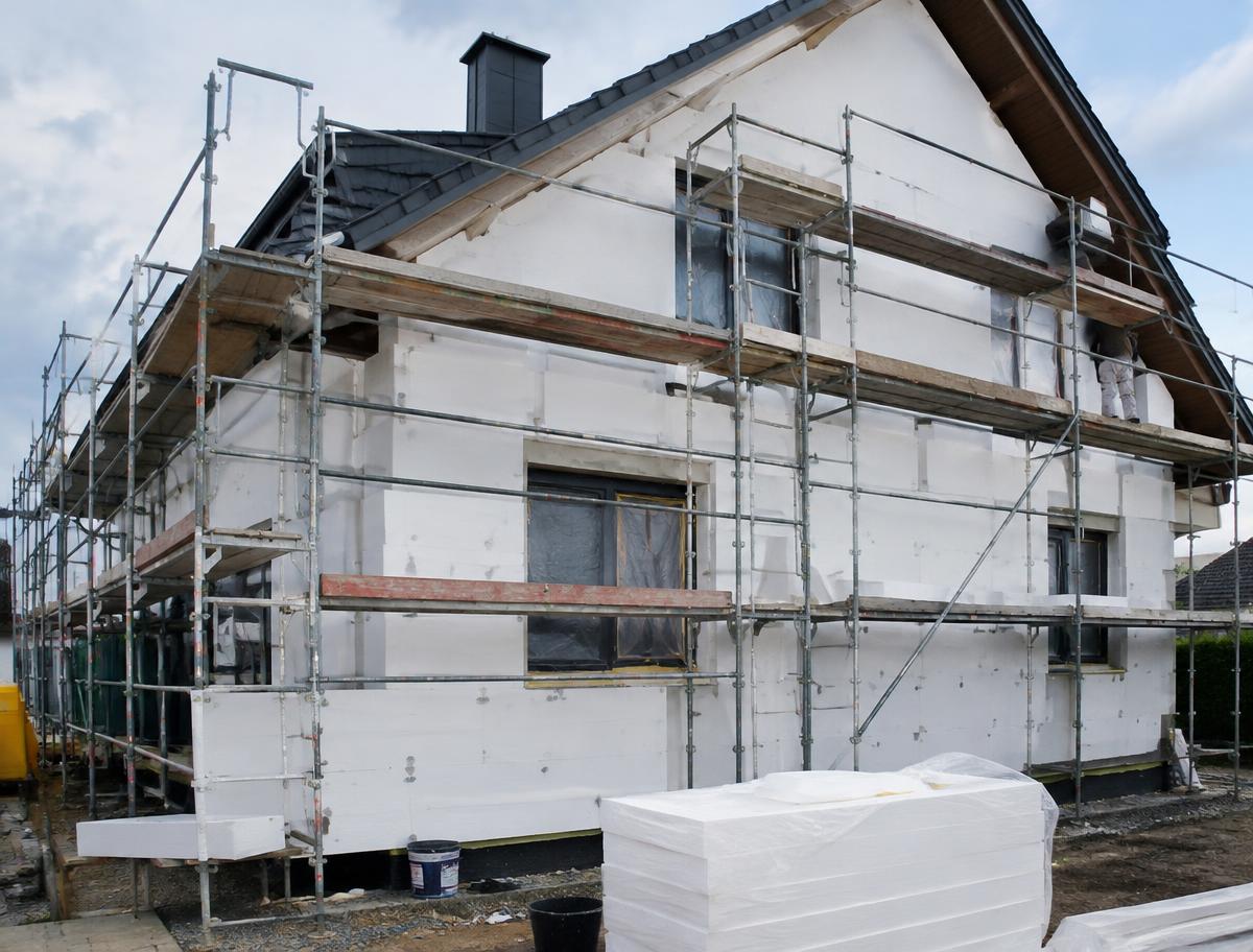 Einfamilienhaus mit Gerüst während der Fassadendämmung